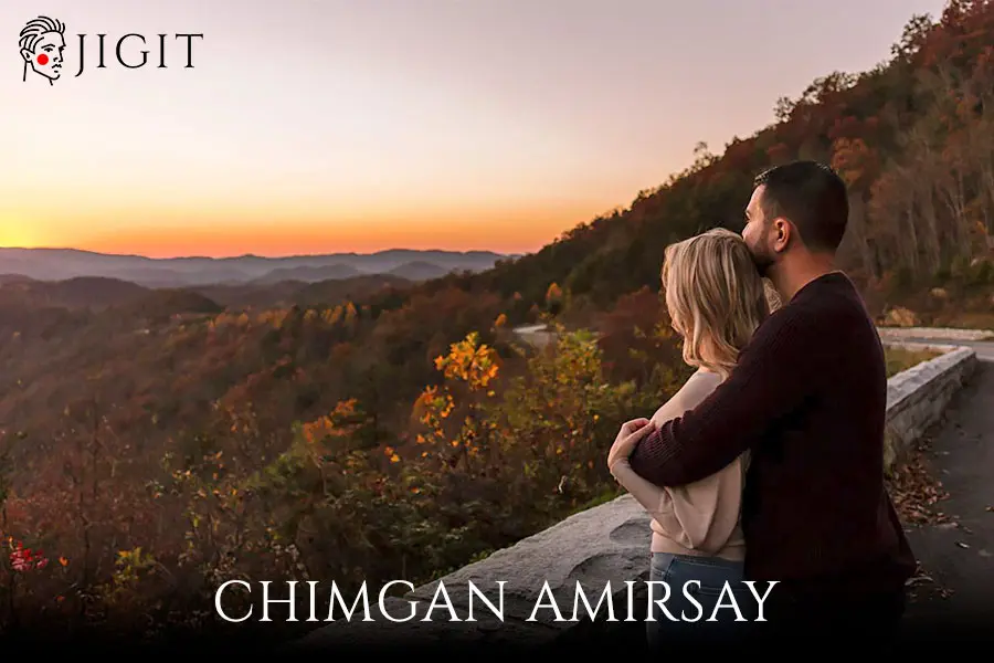 Young lovers on a mountainside watching the sunset jigit-uz